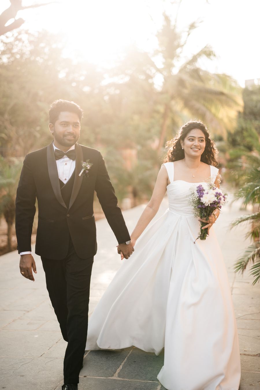 A couple walking together, the groom in black tie